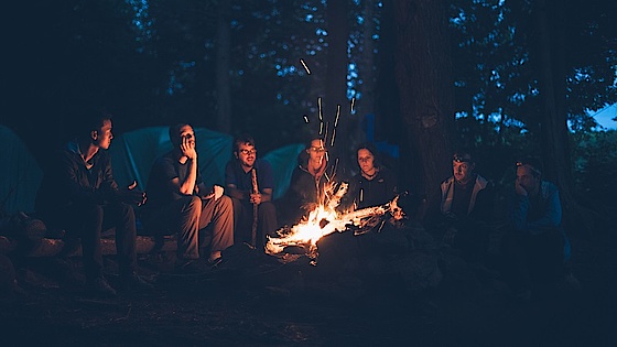 At dele oplevelser med Gud giver flere nuancer Mennesker, der snakker omkring et bål